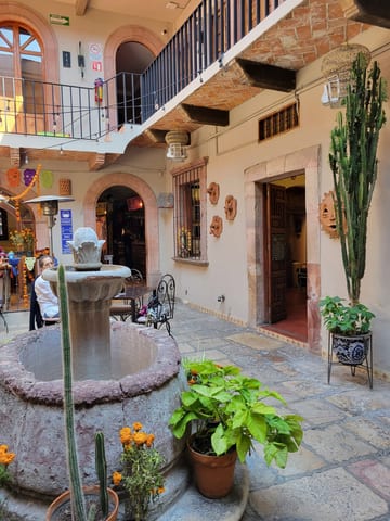 Plant-filled courtyard lined with small shops and upper-level balconies