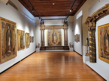 Museum gallery filled with framed paintings of the Virgin of Guadalupe