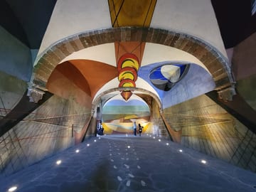 Large colorful abstract mural wrapping around the walls and ceiling of an arched room