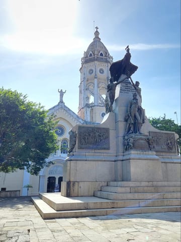 A white church facade and statue in the bright Panama sun